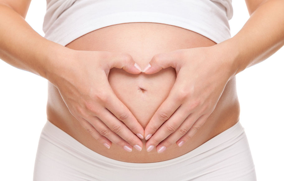 Schwangere Frau mit Händen auf Bauch